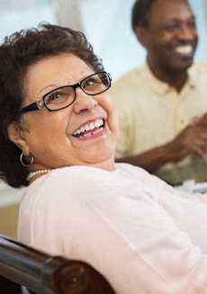 a woman sitting in a hospital bed smiling at a man