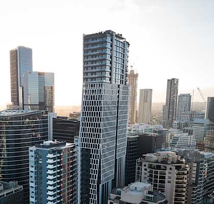 A cityscape with tall buildings and a hazy sky.