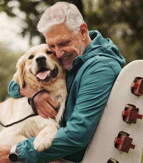 A woman is hugging a dog on a white couch.