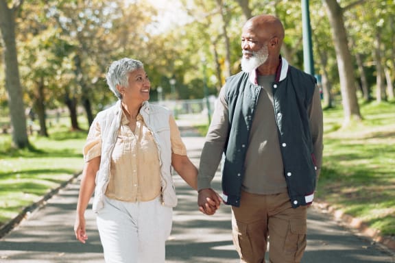 a man and a woman walking down a path in a park