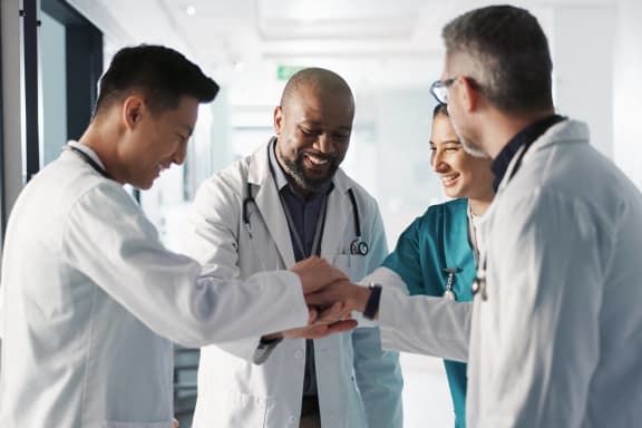 a group of doctors shaking hands with a patient in a hospital