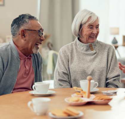 Three elderly people having a conversation over tea.