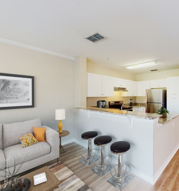 a living room and kitchen with a bar and stools at Audubon Oaks, 33809