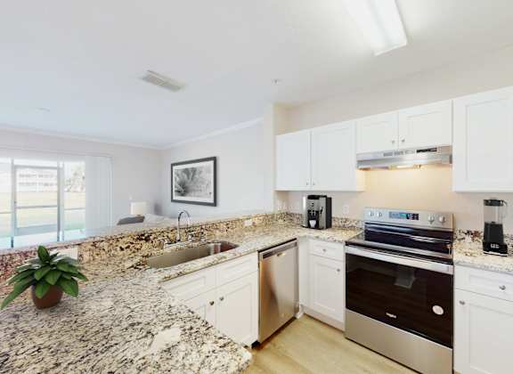 a kitchen with white cabinets and granite countertops