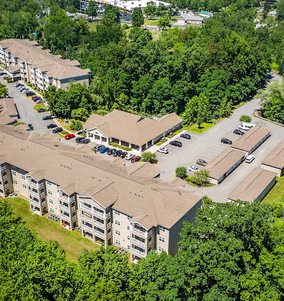 A row of townhouses with a sign that says at Glenmont Abbey Village, 55+ Apartments, New Jersey, 12077