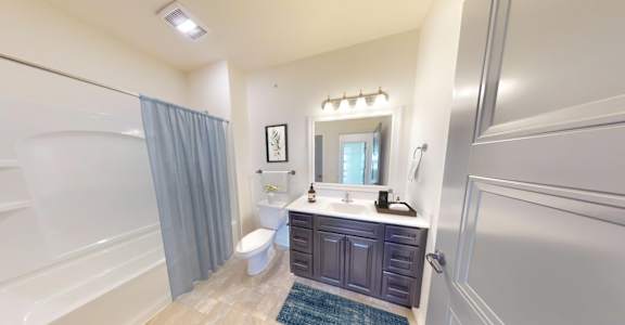 a bathroom with a toilet and a shower and a sink