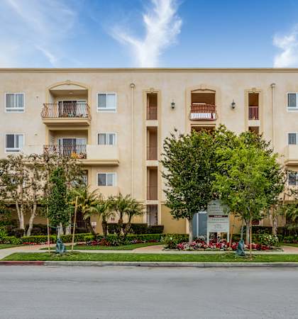 a large apartment building with trees in front of it