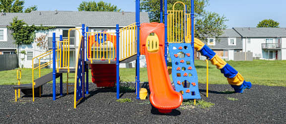 A playground with a slide, swings, and a climbing frame.