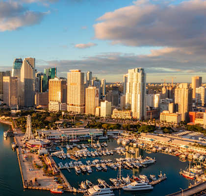 A cityscape with a marina and boats in the foreground.