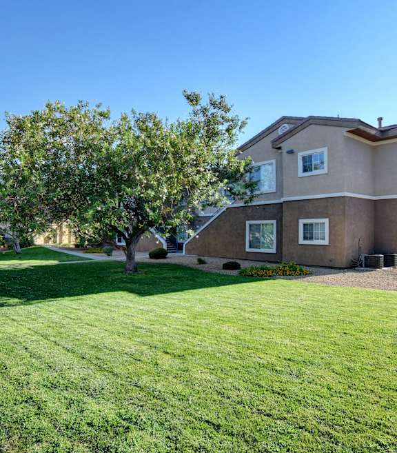 a large house with a lawn and trees in front of it