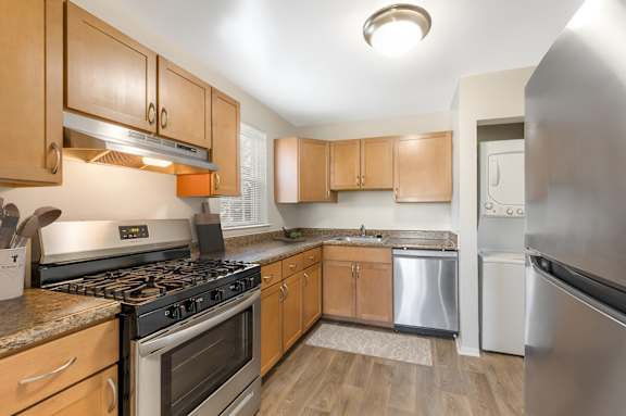 A modern kitchen with a stainless steel refrigerator and grey cabinets.