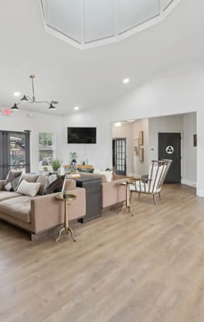 A living room with a couch, chairs, and a television.