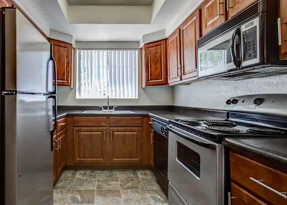A kitchen with wooden cabinets and a black stove top oven.