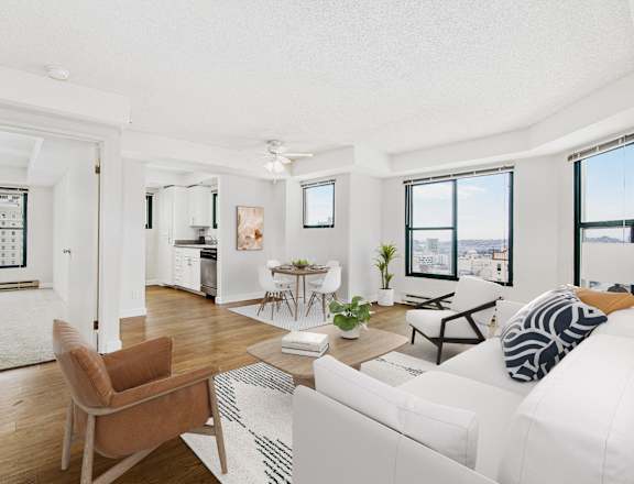 the living room of an apartment with a white couch and a table and chairs