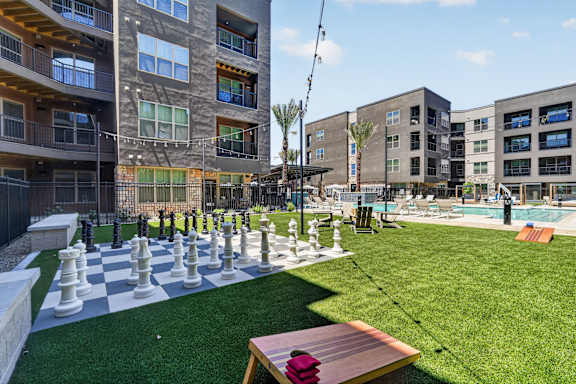 A chess board is set up on a green lawn.