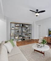 A living room with a couch, a coffee table, a TV, and a plant.