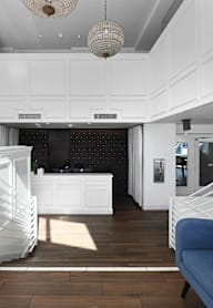 A white kitchen with a blue sofa.
