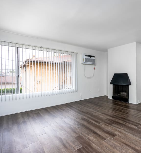 a bedroom with hardwood floors and white walls