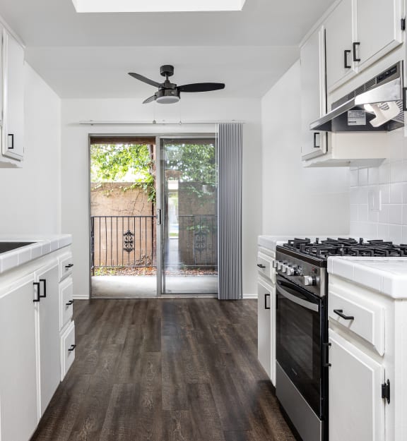 a kitchen with white cabinetry and a black stove top oven