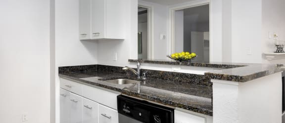a kitchen with white cabinets and granite countertops