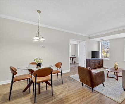 A living room with a dining table and chairs.