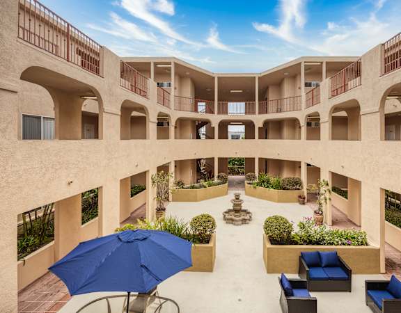 a courtyard with seating and a fountain in the middle of a building