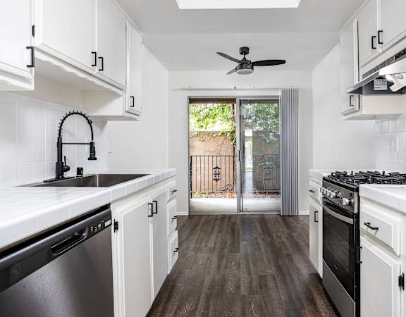a kitchen with white cabinetry and a black stove top oven