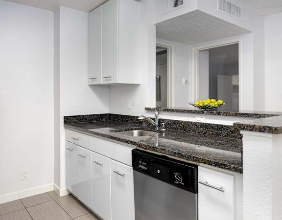 a kitchen with white cabinets and granite countertops