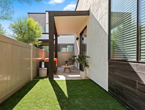 A modern house with a wooden fence and a glass wall.