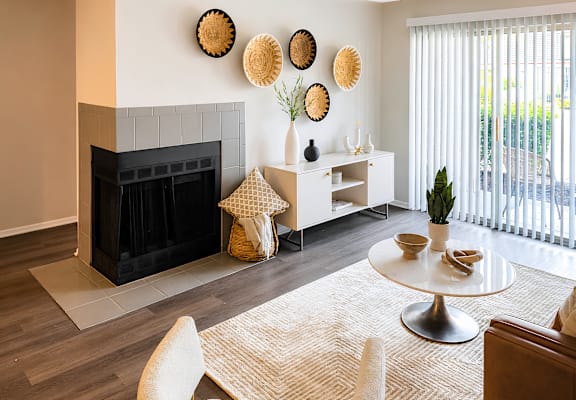 A living room with a fireplace and a table with a plant on it.