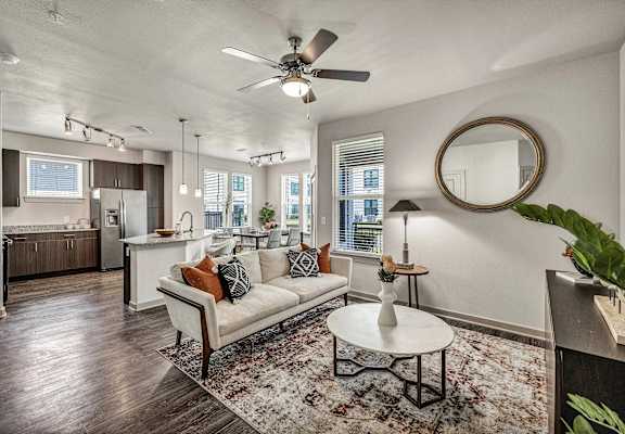 A living room with a white couch and a rug.