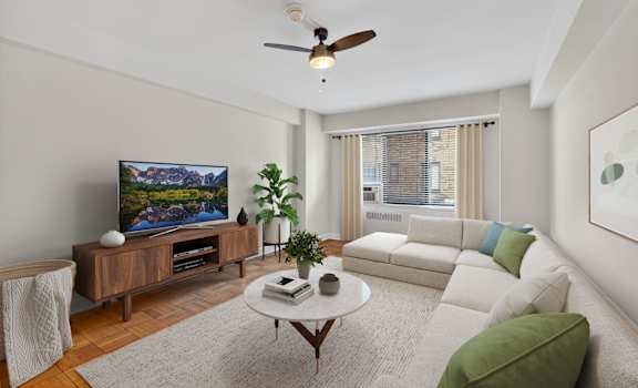 A living room with a flat screen TV, a white couch, and a coffee table.