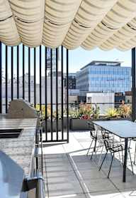 A patio with a table and chairs under a striped awning.