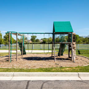 a playground with a monkey bars swing set and basketball hoop