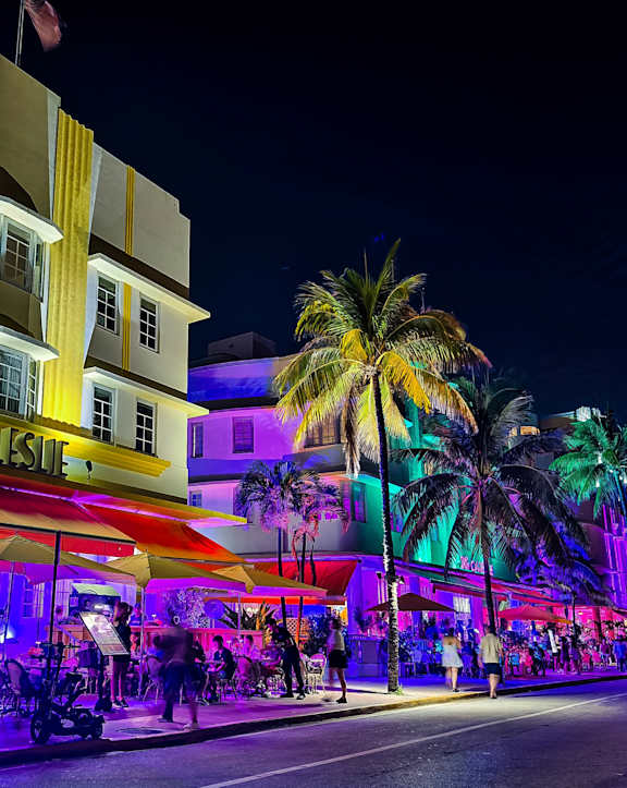 a city at night with people on the street and buildings