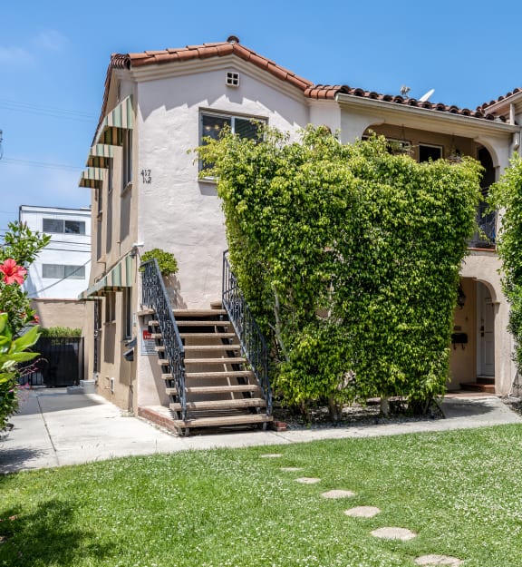 a white house with a balcony and a grassy yard