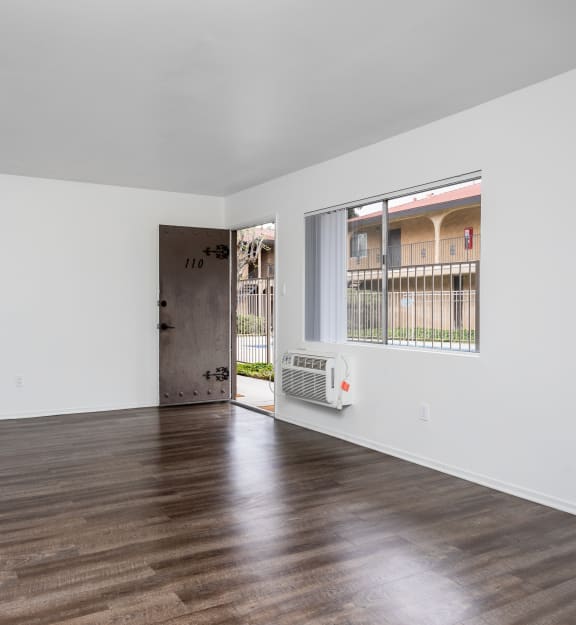 a bedroom with hardwood floors and white walls