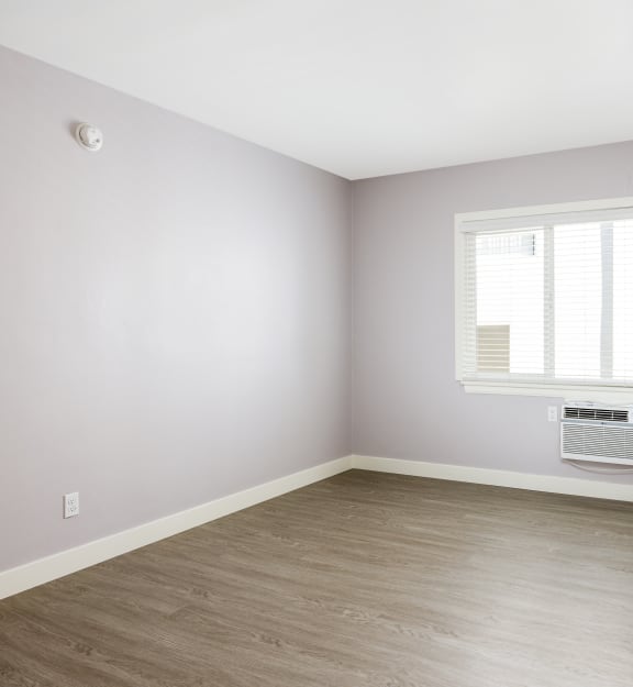 an empty room with a radiator and a window