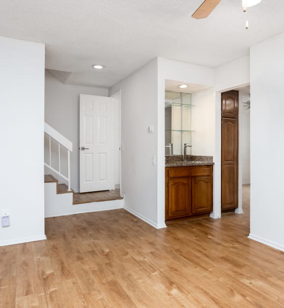 a living room with hardwood floors and white walls