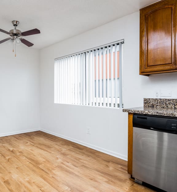 a kitchen and living room with hardwood floors and a ceiling fan