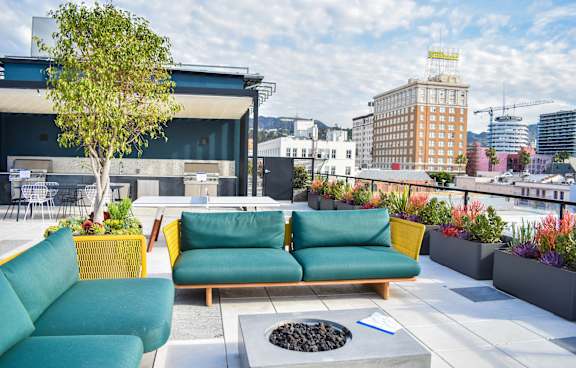 A patio with a green couch and a yellow chair.