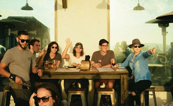 A group of people are sitting around a table in a restaurant.