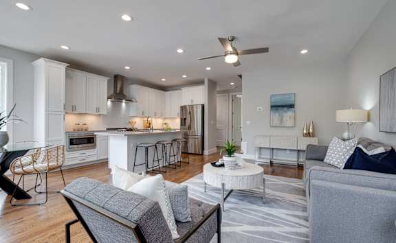 A modern living room with a kitchen area in the background.