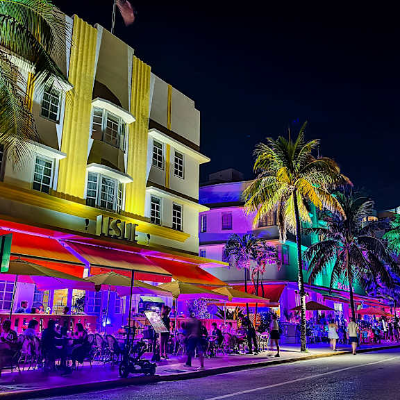 a city at night with people on the street and buildings