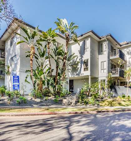 a large apartment building with palm trees in front of it