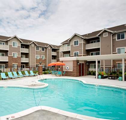 A swimming pool in front of apartment buildings.