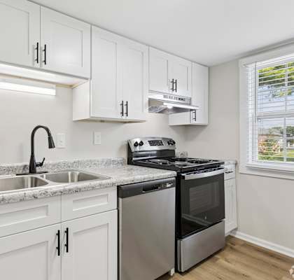 A kitchen with white cabinets and stainless steel appliances.