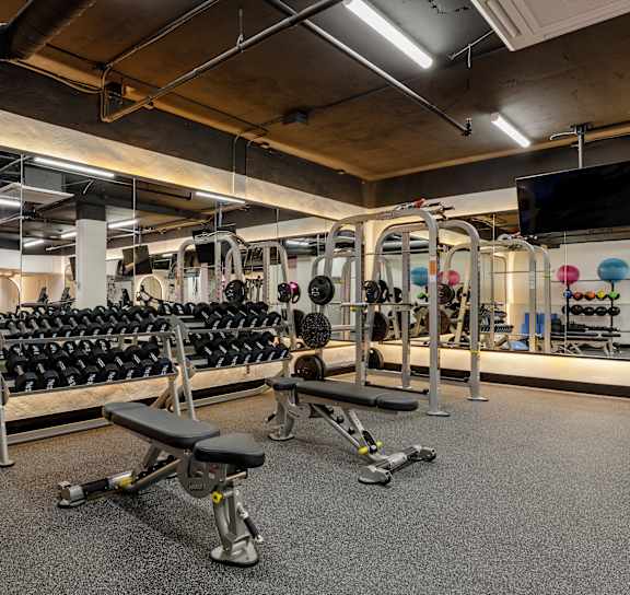 a gym with treadmills and other exercise equipment in a room with a window