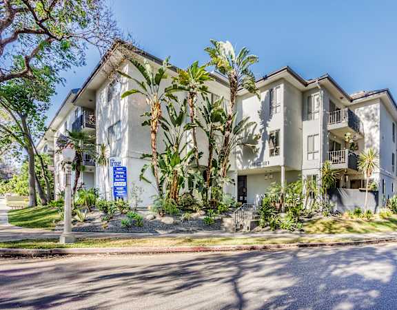 a large apartment building with palm trees in front of it
