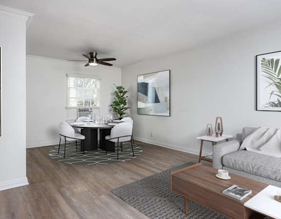 a living and dining room with white walls and a wood floor
